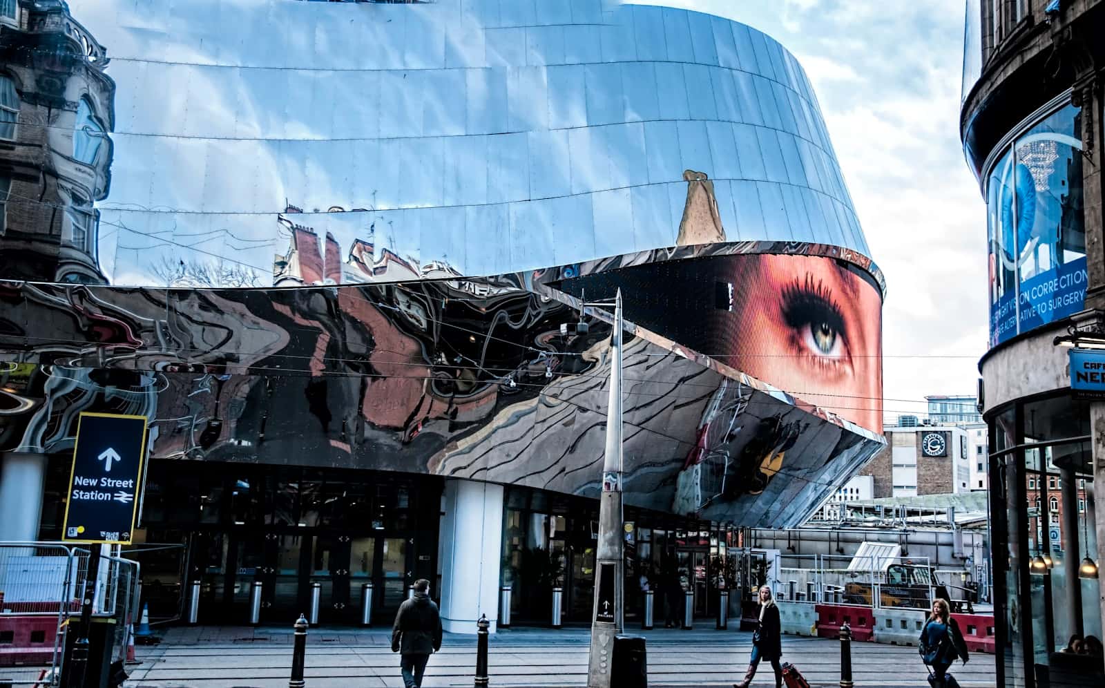 People walking past a glass building in Birmingham city centre
