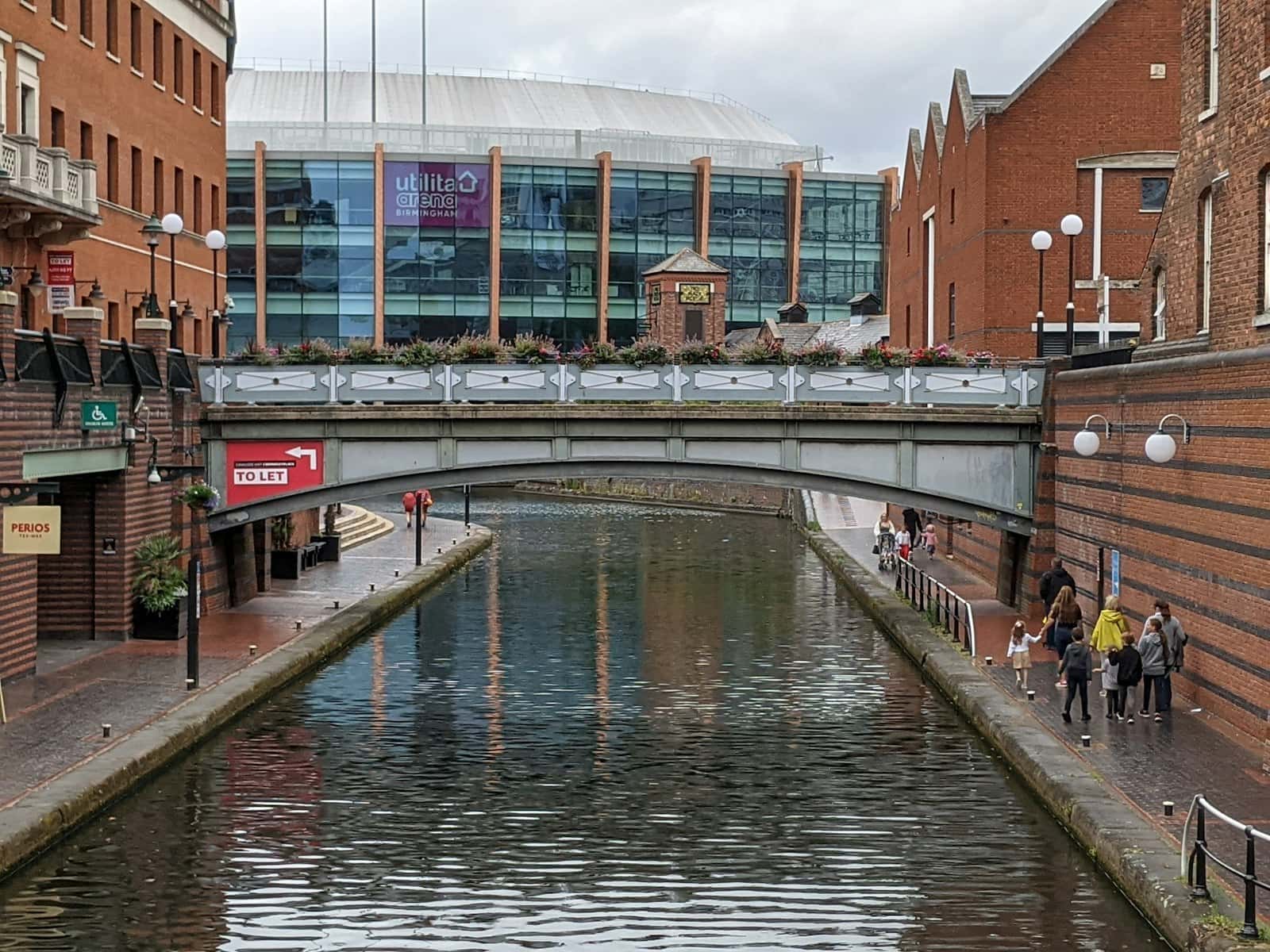 Shoppers walking past a brick building in Birmingham