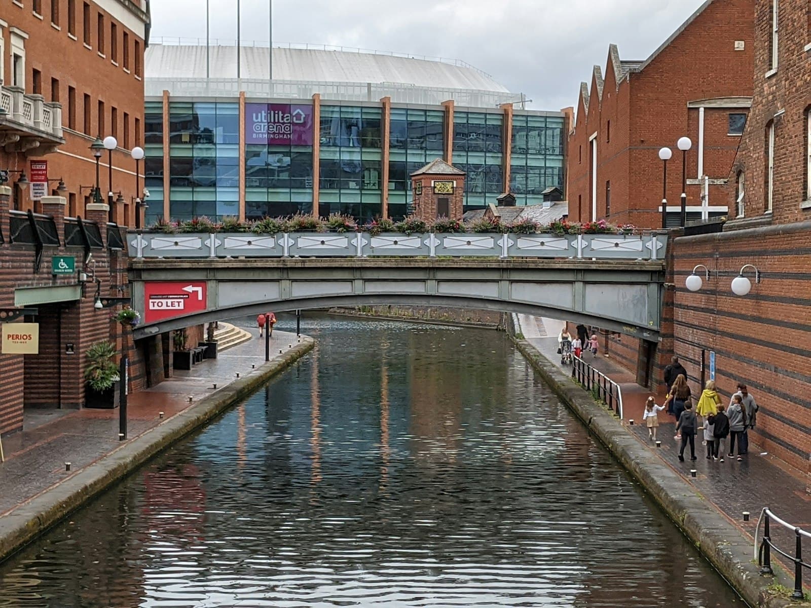 Shoppers walking past a brick building in Birmingham