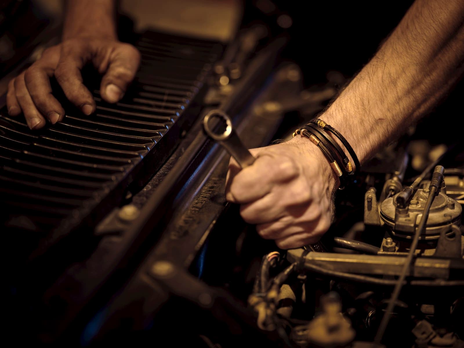 Hands working on an engine with a wrench